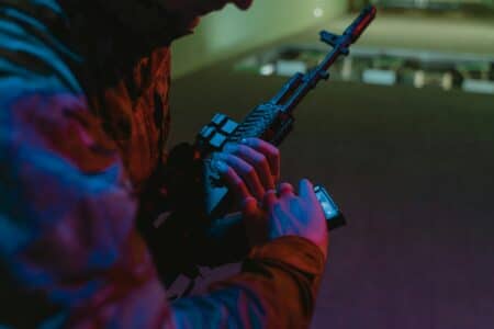 Close Up Of A Person Handling A Tactical Rifle With Colorful