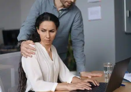 Workplace,harassment.,male,boss,touching,his,young,female,assistant,while