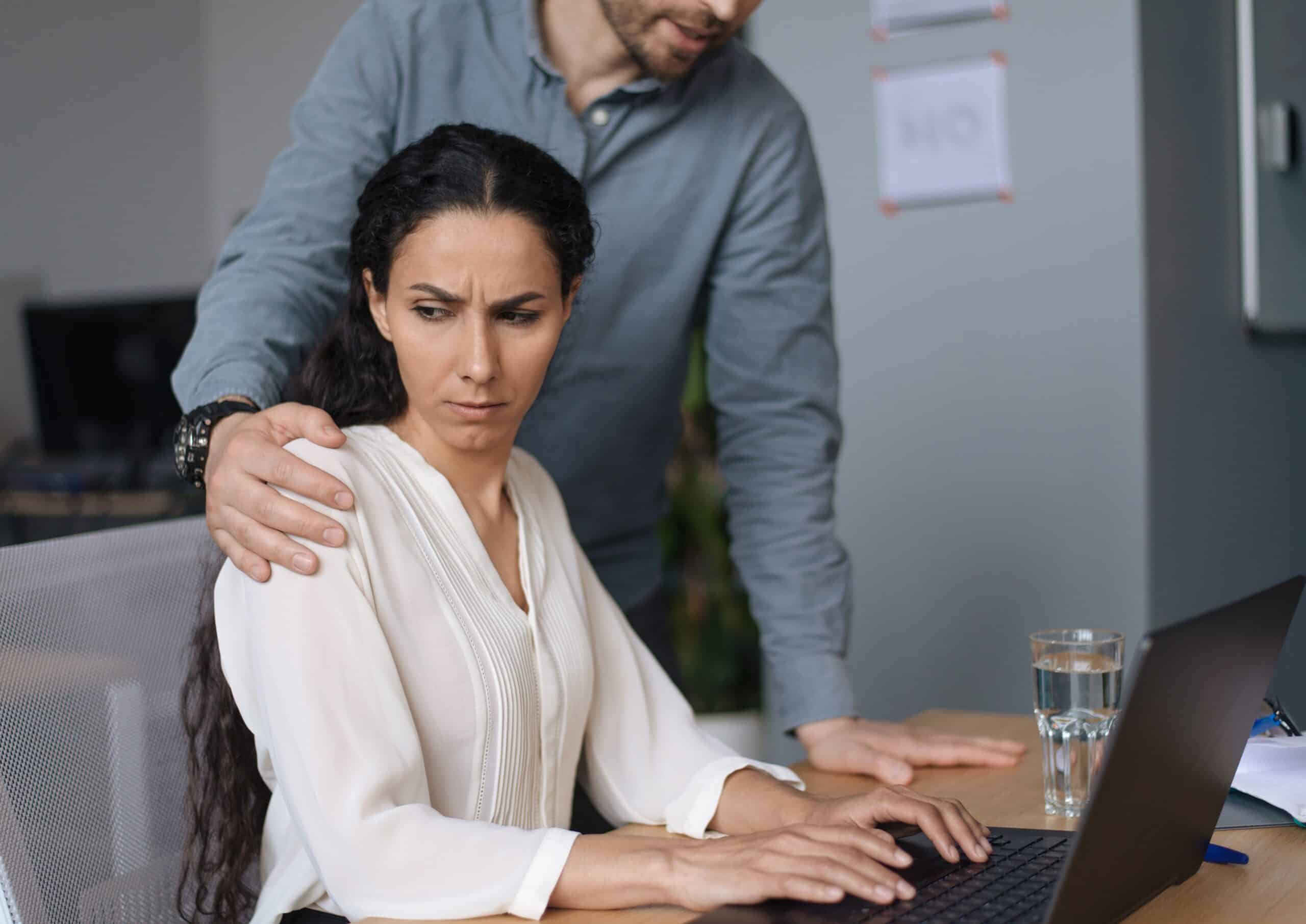 Workplace,harassment.,male,boss,touching,his,young,female,assistant,while